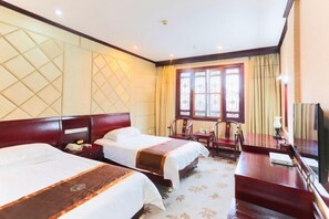 A hotel room with two beds, a desk, a chair, a television, and a window with curtains. - Chabofu Charenju Hotel (Wuyuan)