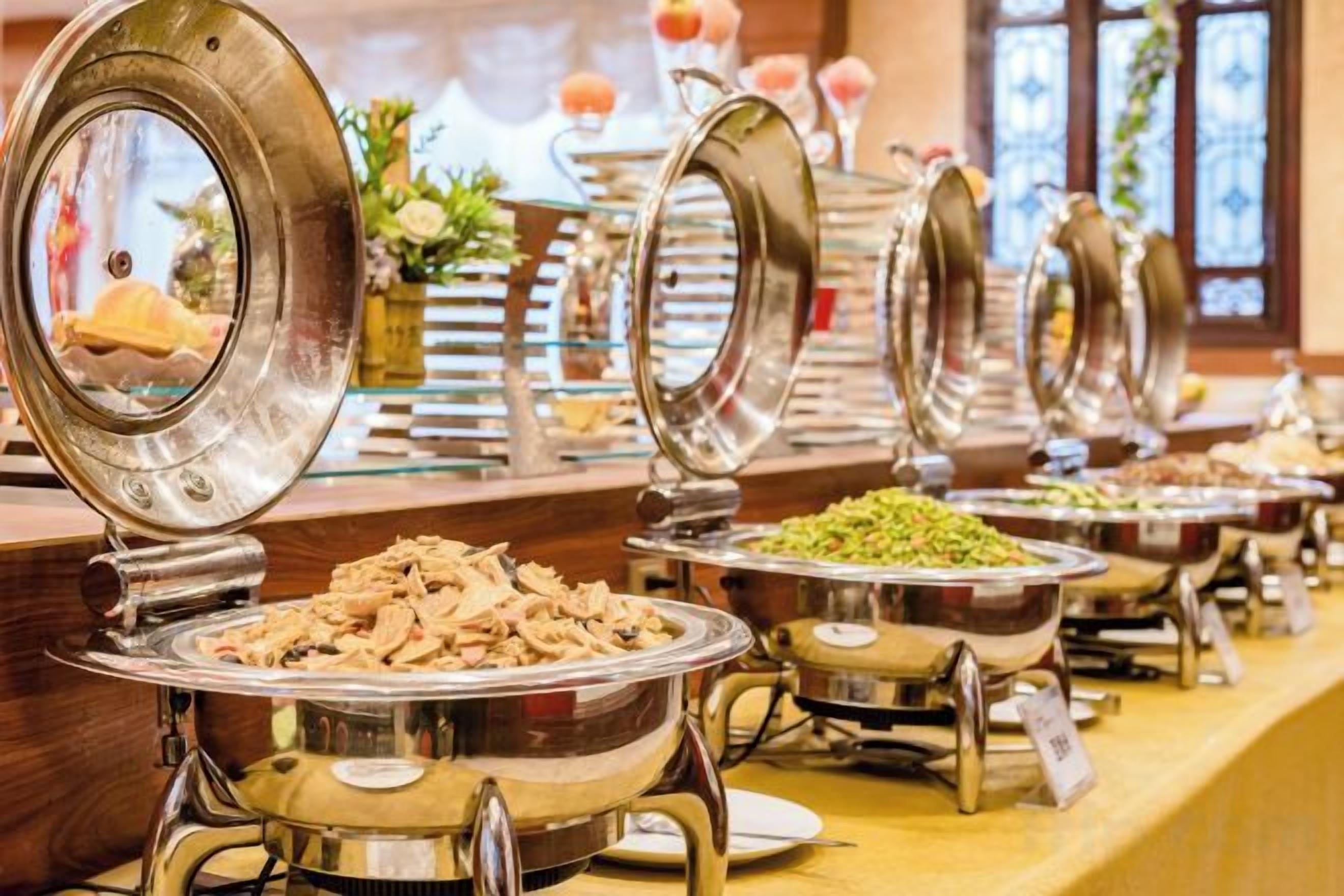 A buffet with various food items and a glass display case in the background.