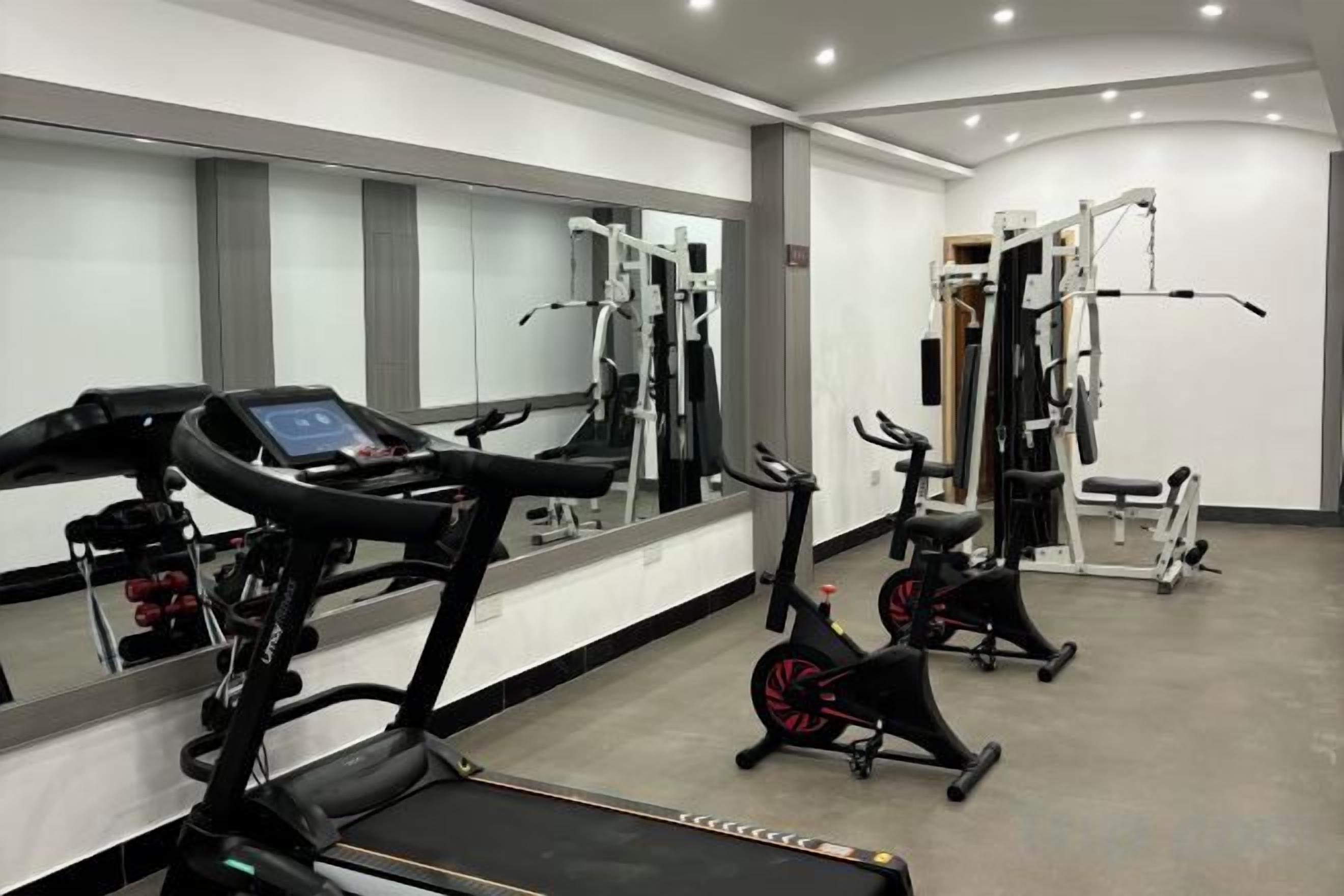 A gym with treadmills, stationary bikes, and weight machines.