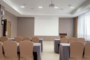A conference room with a projector screen, tables, and chairs arranged for a meeting. - Chabofu Charenju Hotel (Wuyuan)