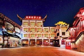 A traditional building with multiple stories, featuring a prominent red sign at the top. - Chabofu Charenju Hotel (Wuyuan)