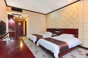 A hotel room with two beds, a desk, and a TV. - Chabofu Charenju Hotel (Wuyuan)