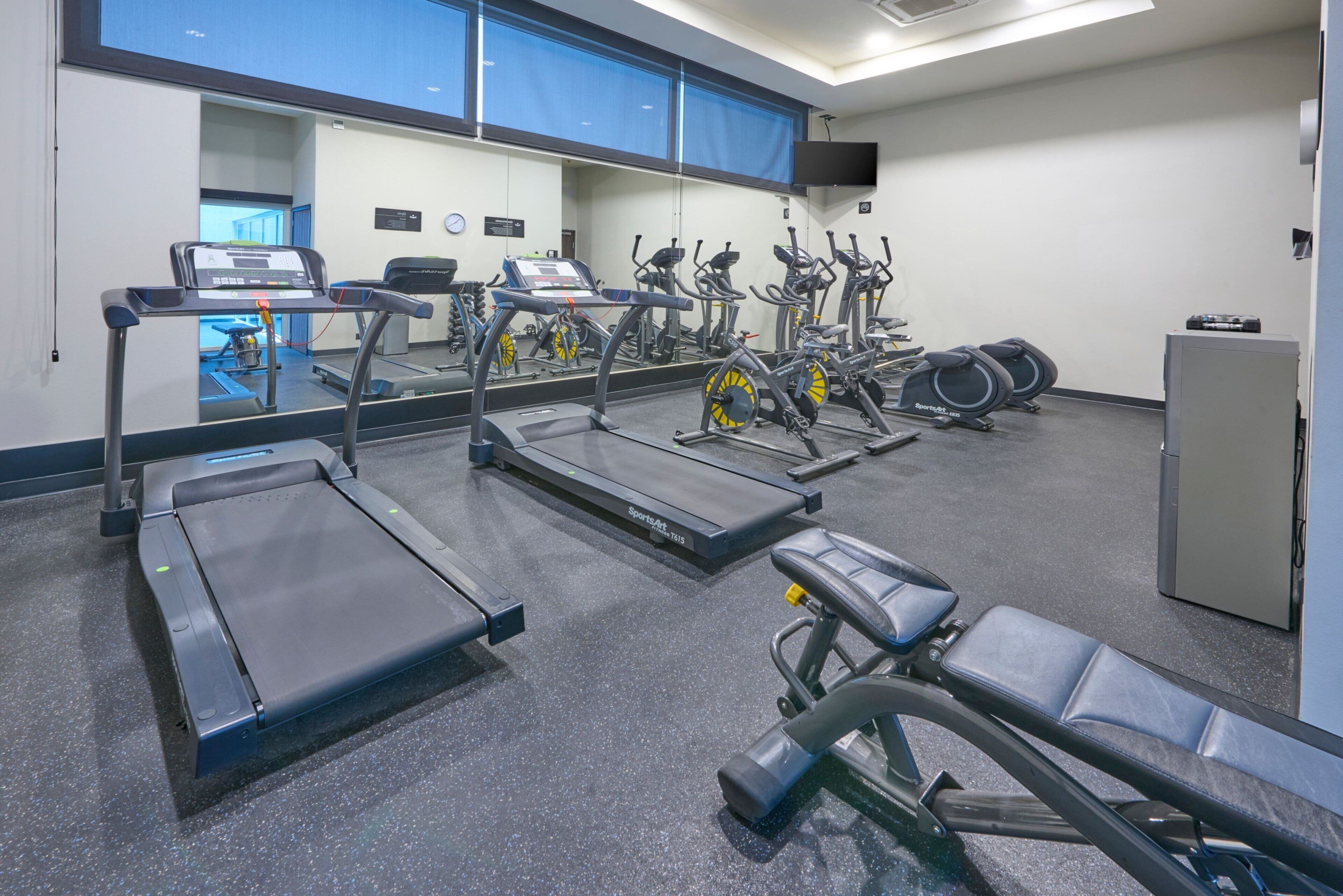 Ein Fitnessstudio mit Laufbändern, Ergometer und Krafttrainingsgeräten.