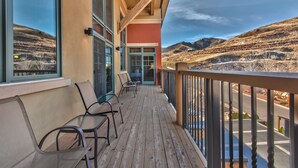 A wooden deck with chairs, a glass door, and a view of a hilly landscape. - Miners Club by Canyons Village Rentals (Park City)