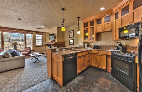 A spacious kitchen with wooden cabinets, a built-in dishwasher, and a large stove.