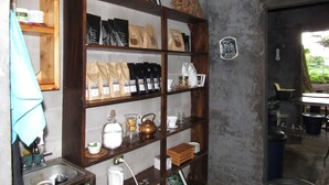A kitchen with a wooden shelf holding various kitchen items and a coffee machine. - Ataco Luxury Cabin (Concepcion de Ataco)