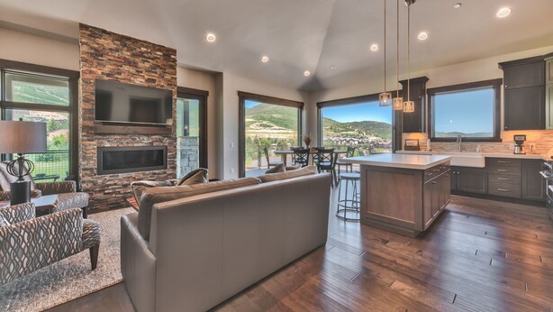 A spacious living area with a stone fireplace, a large flat-screen TV, and a comfortable seating arrangement.
