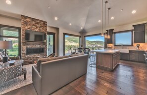 A spacious living area with a stone fireplace, a large flat-screen TV, and a comfortable seating arrangement. - Blackstone by Canyons Village Rentals (Park City)