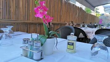 A table set for dining with a potted plant, condiment containers, and a candle.