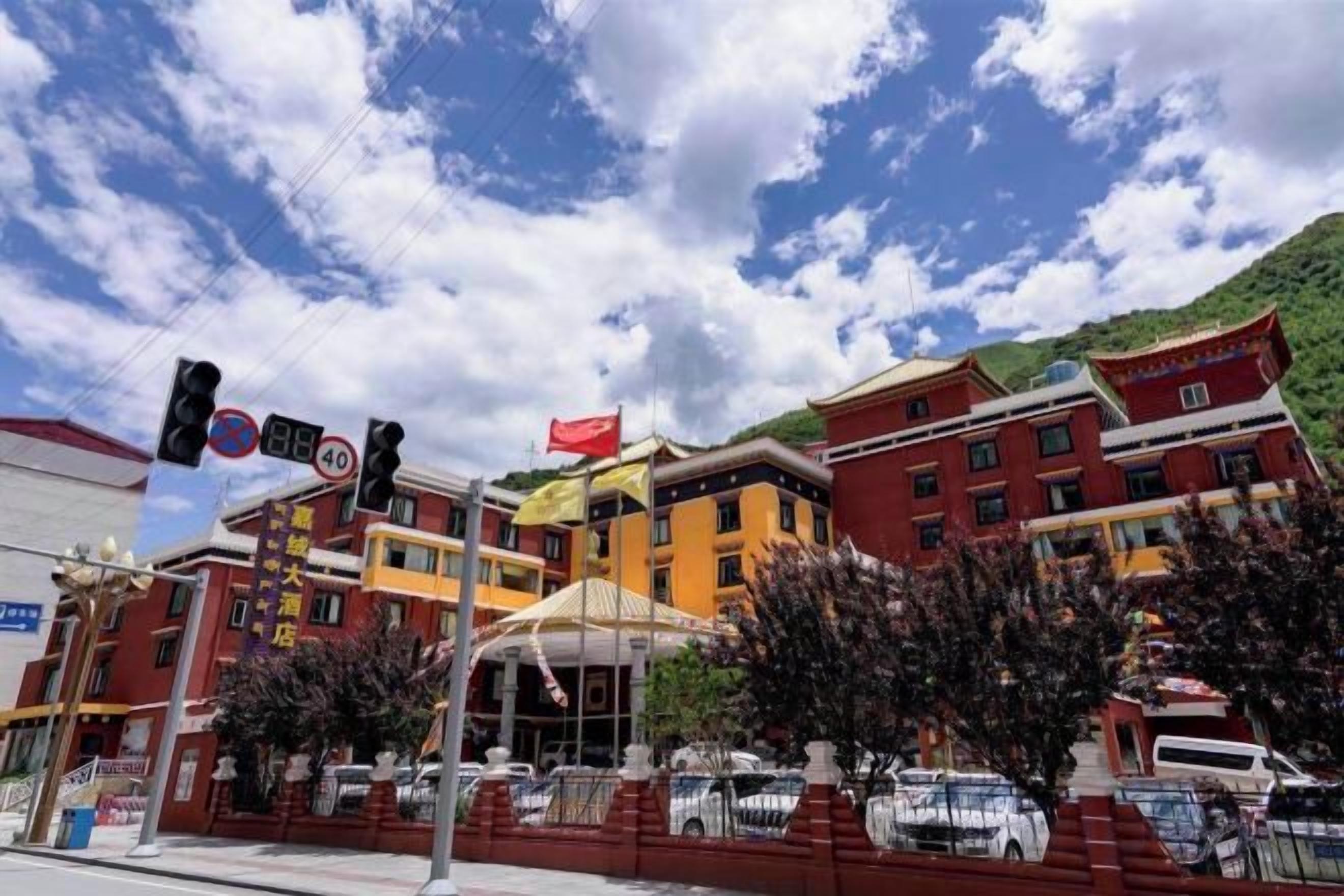Um edifício de vários andares com fachada vermelha, toldo amarelo e uma bandeira.