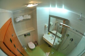 Un baño pequeño con inodoro, lavabo y ducha.