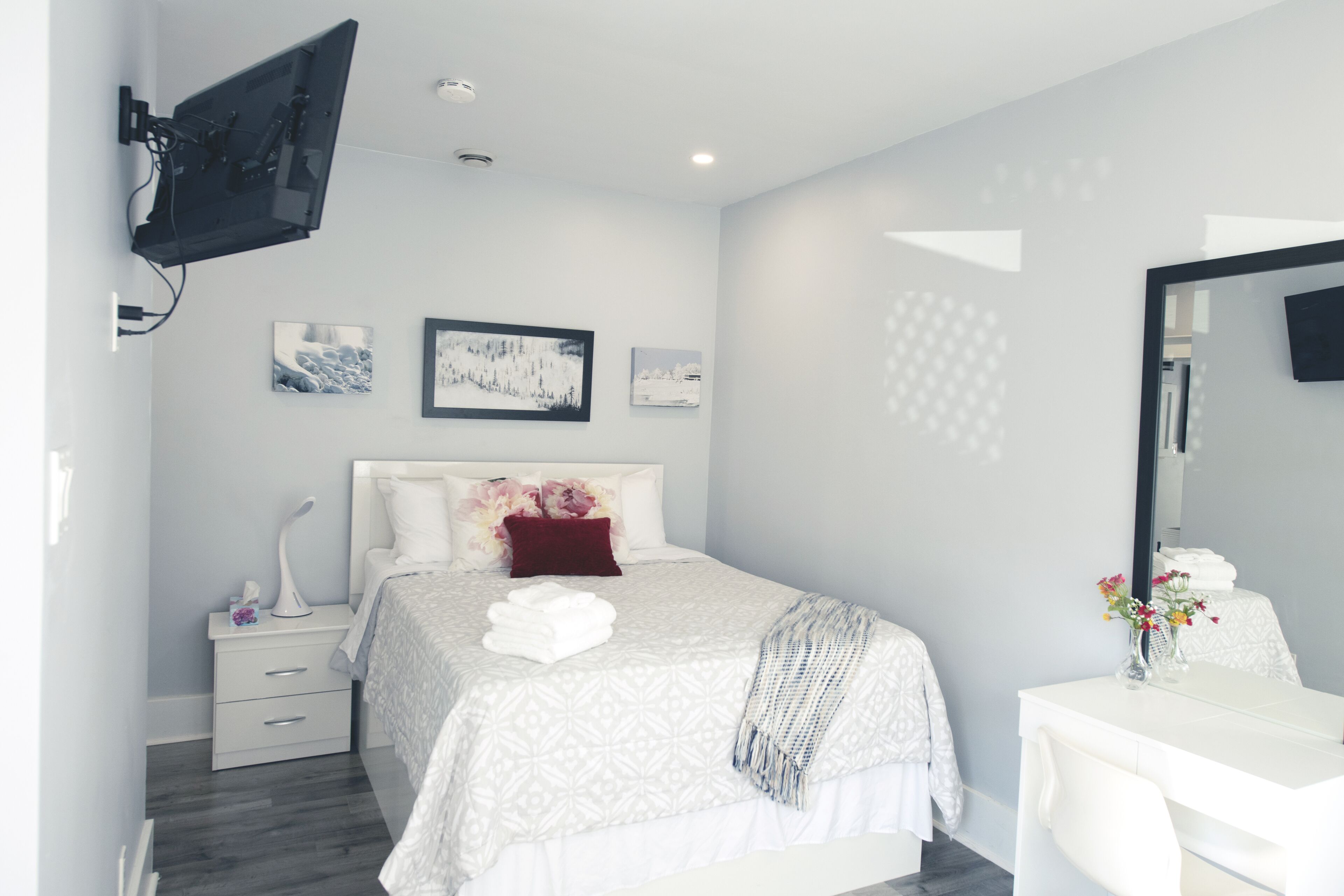 Una camera da letto moderna con un letto, un comodino e un grande specchio.