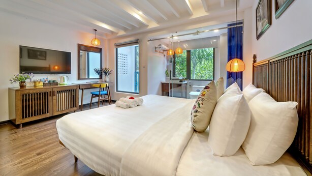 Una habitación de hotel moderna con una cama grande, un escritorio y un televisor.