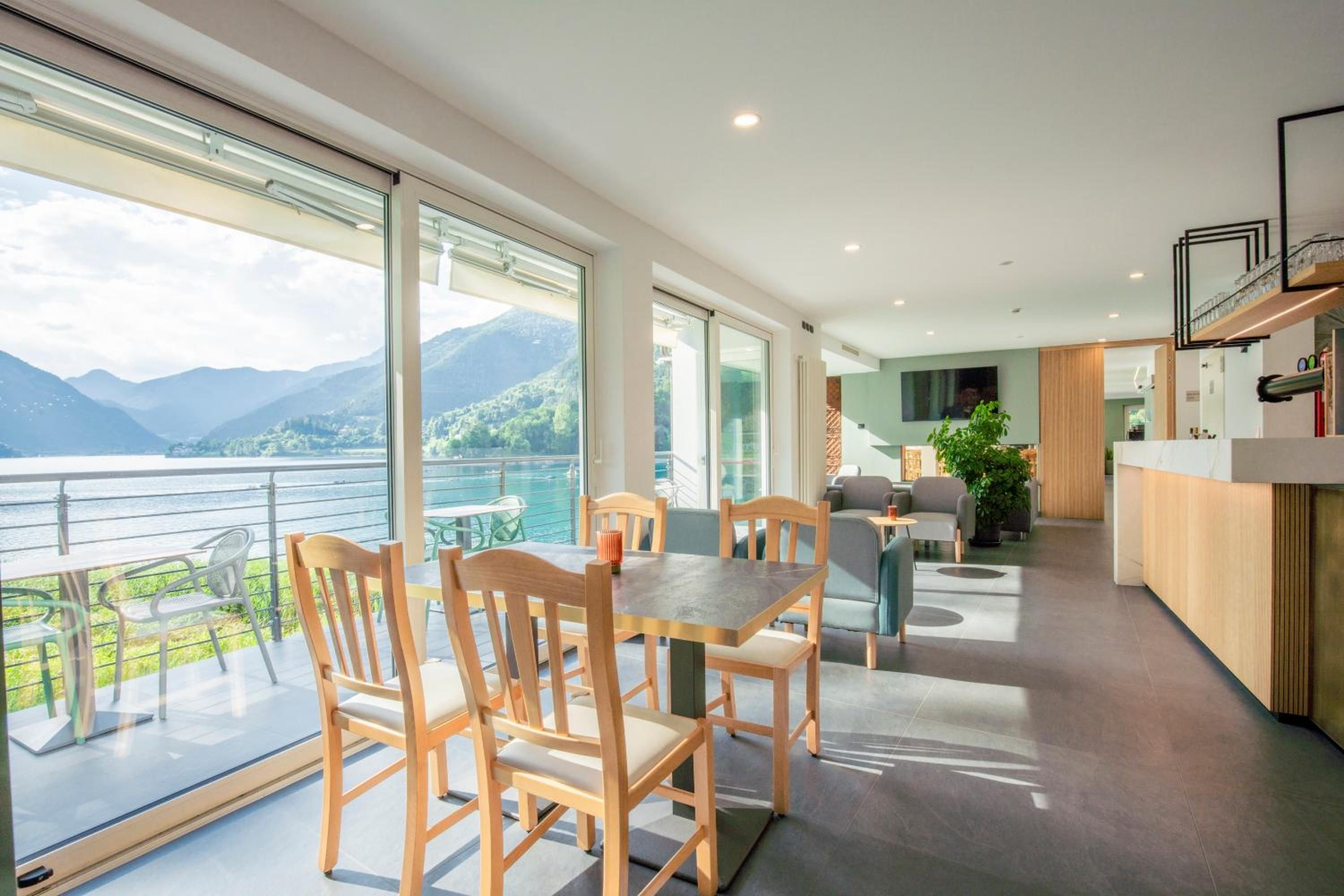 A modern interior with a dining area, kitchen, and a balcony with a mountain view.