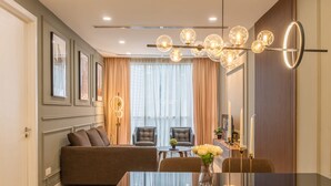A modern living room with a sofa, chairs, a coffee table, and a decorative light fixture.