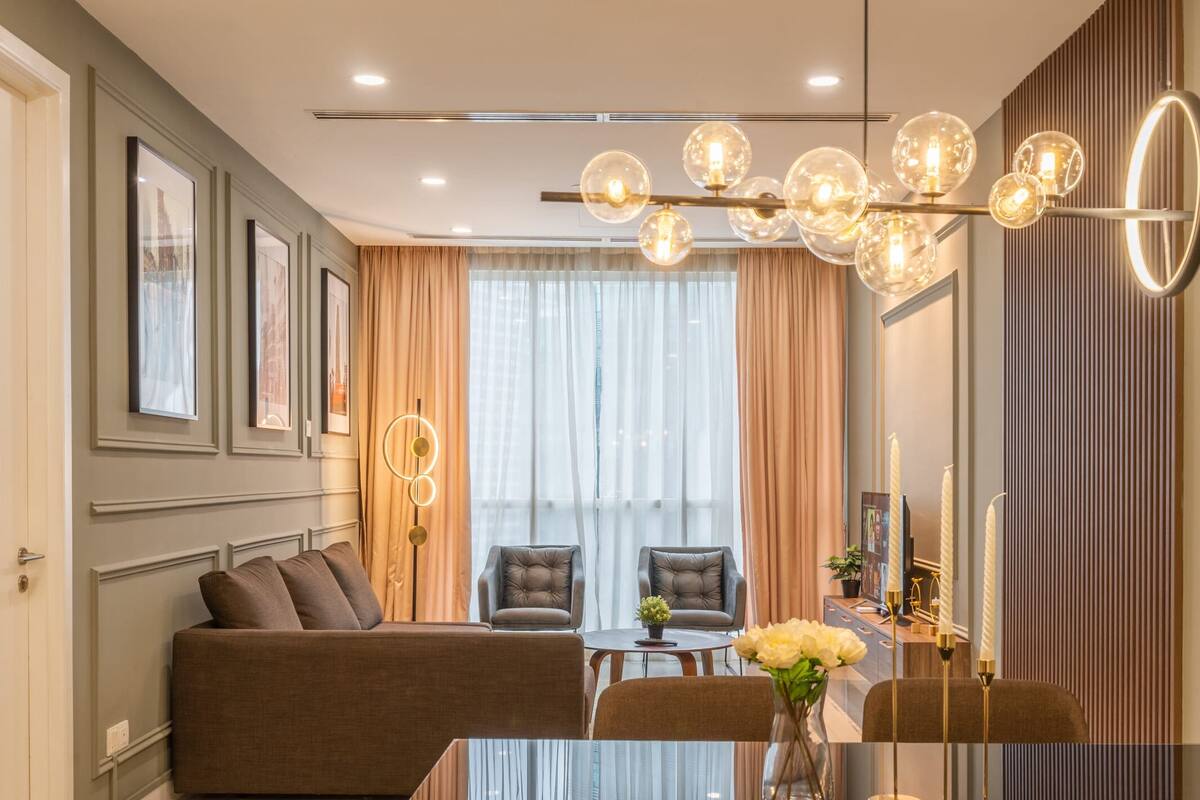 A modern living room with a sofa, chairs, a coffee table, and a decorative light fixture.