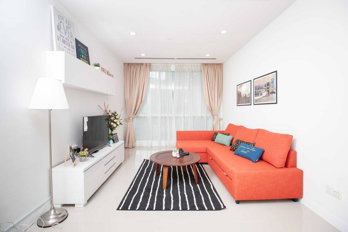 A modern living room with a sofa, a coffee table, a TV, and a floor lamp.