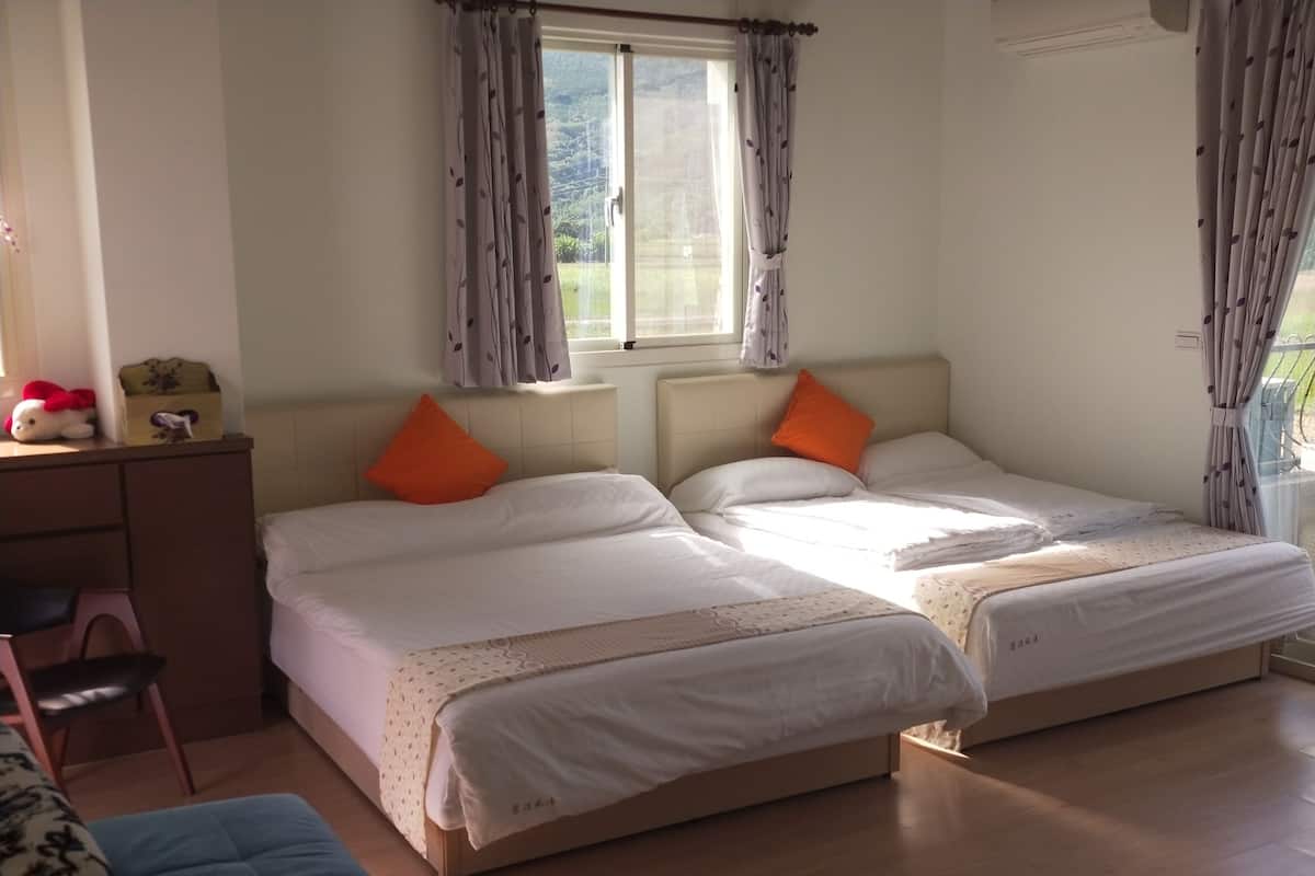 Un dormitorio con dos camas, un escritorio y una silla.