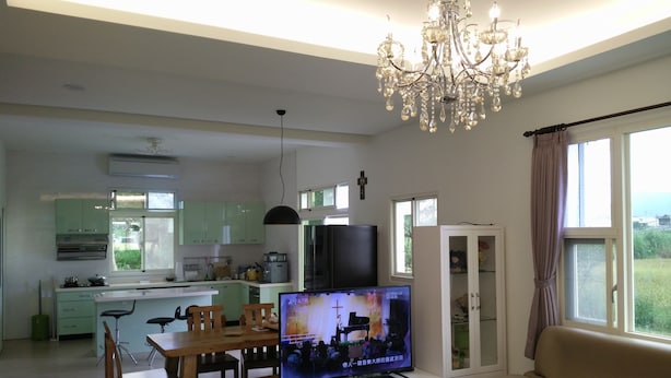 Una sala moderna con televisor, sofá y comedor.
