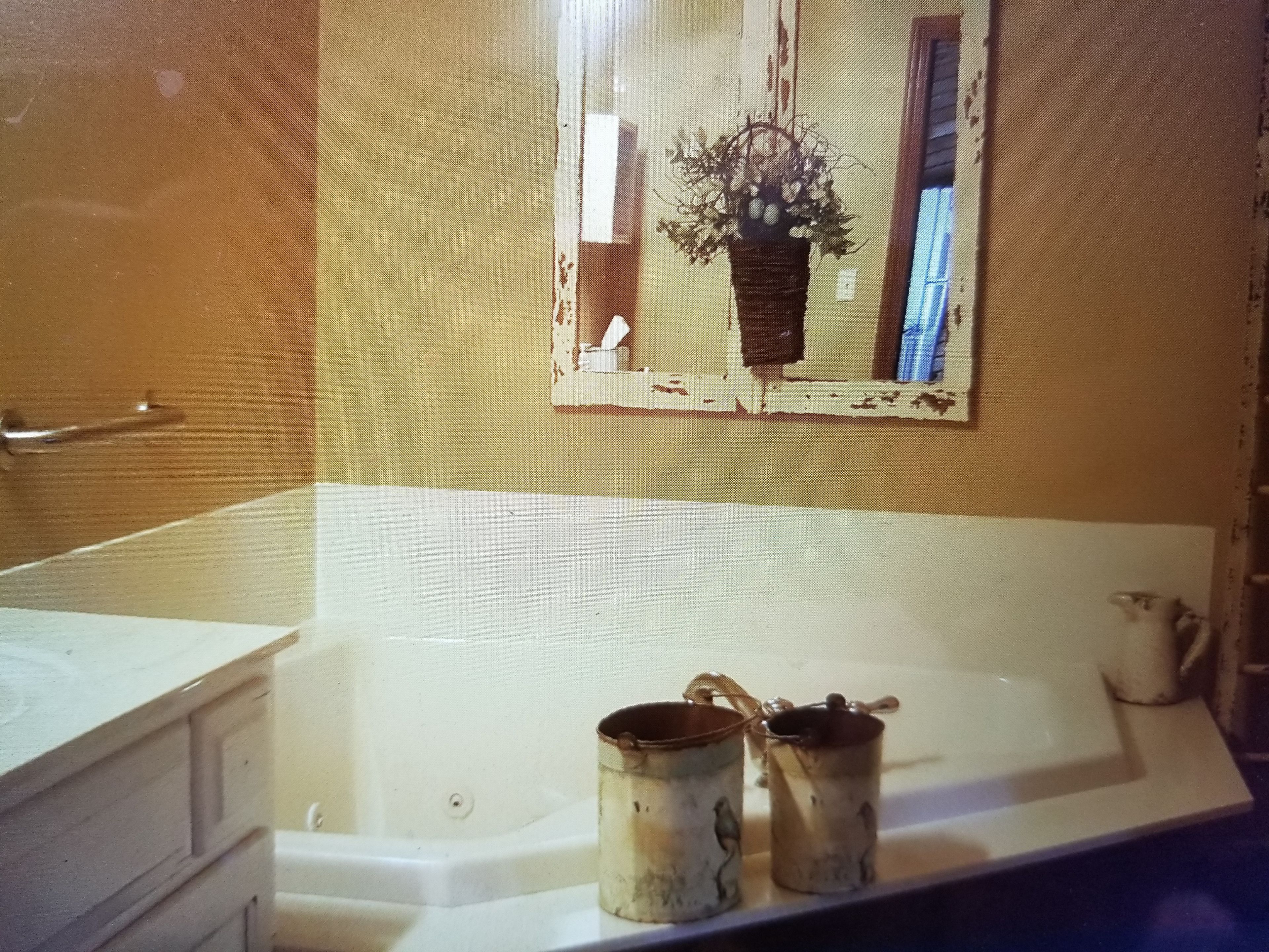 Een badkamer met een bad, een wastafel en een spiegel.