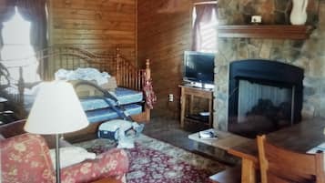 Huisje (New Blessings Homestead Cabin) | Woonkamer | Een flatscreentelevisie en een open haard