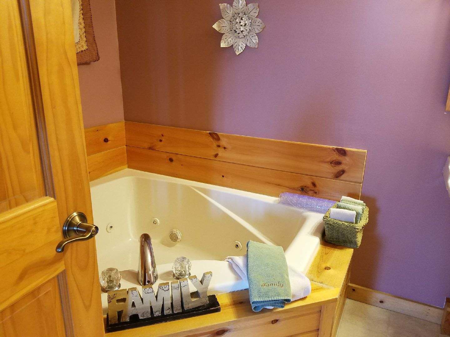 Een badkamer met een houten wastafelmeubel, een bad en een wastafel.