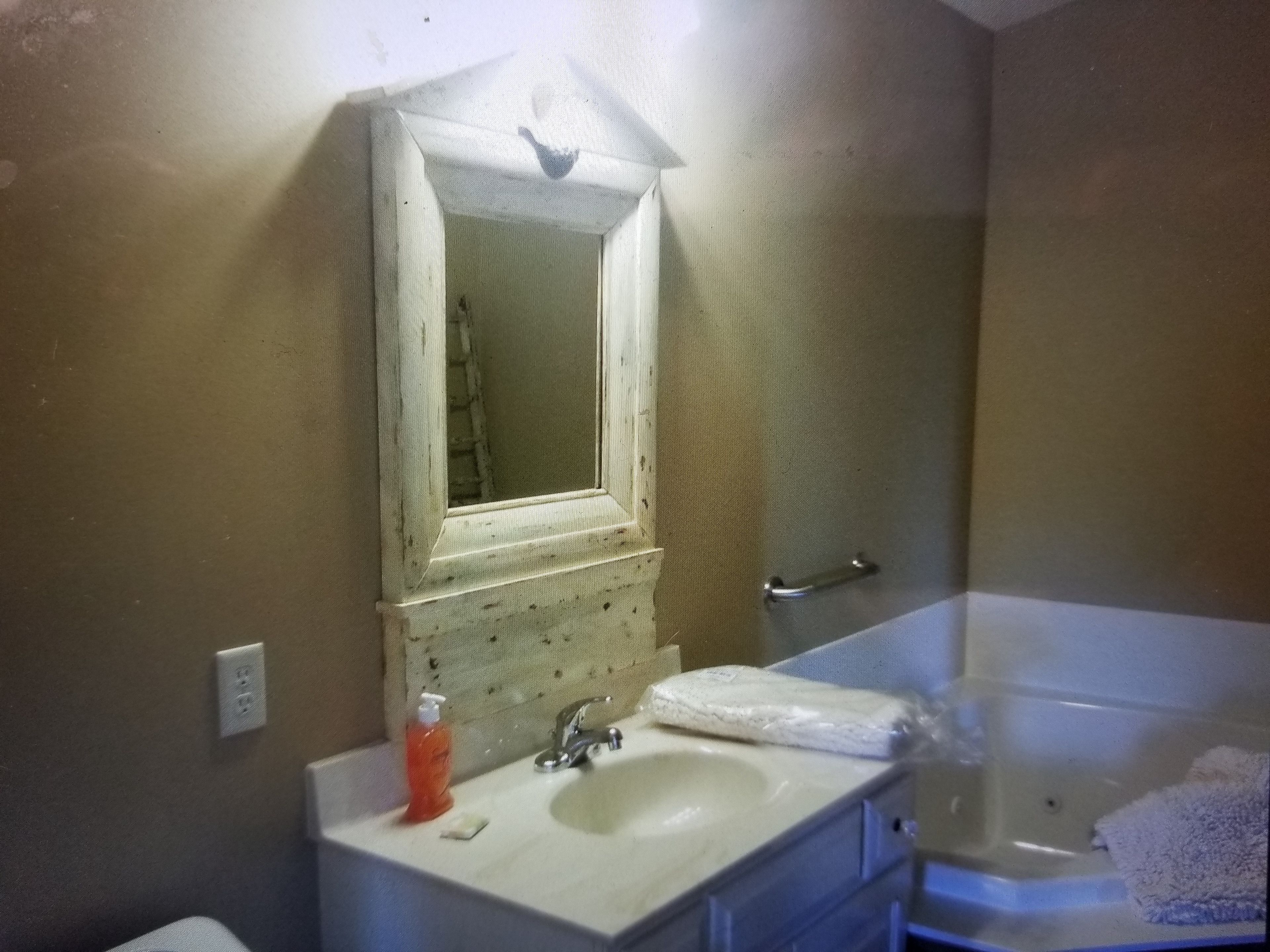 A bathroom with a sink, mirror, faucet, and a bathtub.