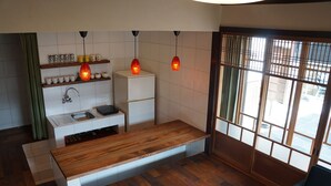 Une cuisine moderne avec un plan de travail en bois, des meubles blancs et des luminaires suspendus.