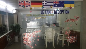Un espace d’accueil orné des drapeaux de l’Angleterre, de l’Allemagne, de la Grèce, de l’Australie et de l’Ukraine. On y trouve des chaises et un comptoir d’accueil.