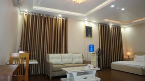 Une chambre d’hôtel avec un canapé, un lit, une table et un ventilateur de plafond.