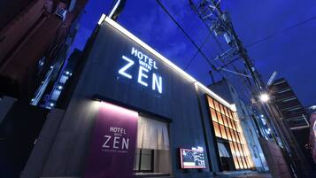 A modern hotel with a prominent sign reading "HOTEL WITH ZEN TIMELESS RESORT".