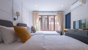 A hotel room with two beds, a TV, a desk, and a window with curtains. - The Mellow Pillow at Chiang Mai Gate (Chiang Mai)