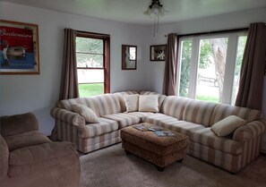 Relax in this inviting living room with a large sectional sofa and matching ottoman, perfect for unwinding.
