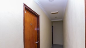 A narrow hallway with a wooden door marked '205' and a light switch on the wall. - Fully Hotel Johor Jaya (Johor Bahru)