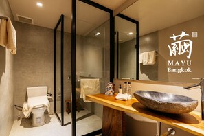 A modern bathroom with a glass shower enclosure, a wooden vanity with a stone sink, and a mirror. - MAYU Bangkok Japanese Style Hotel (Bangkok)