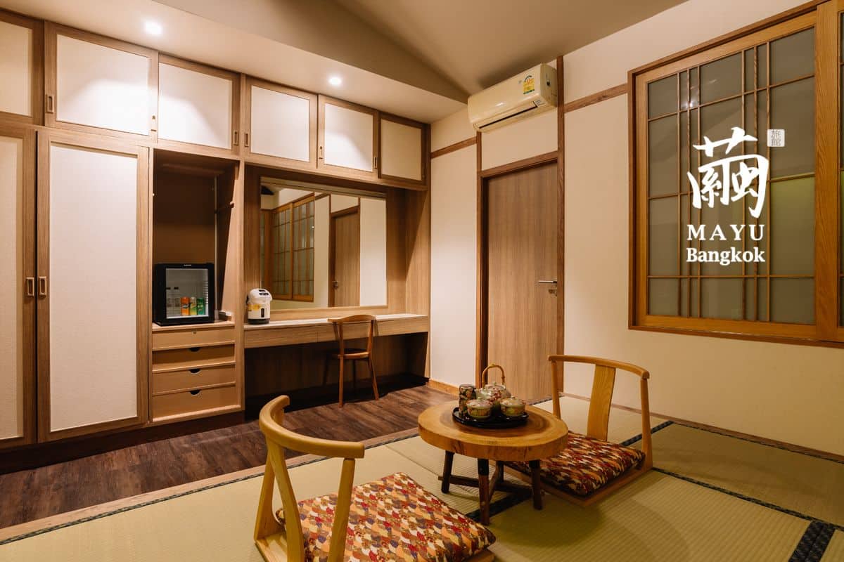 A traditional Japanese-style room with tatami flooring, a low table with a tea set, and sliding wooden doors.