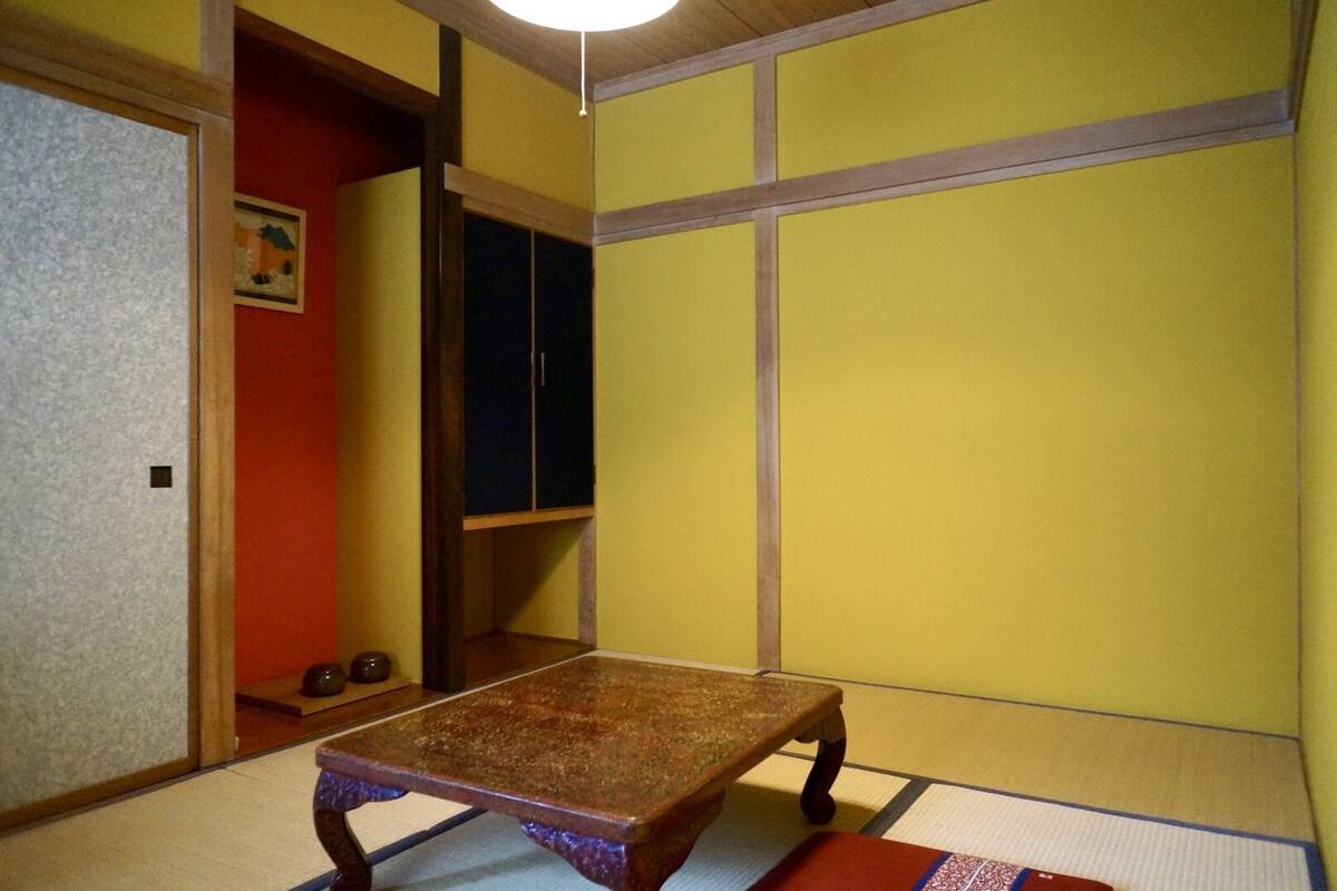 A tatami mat room with a low wooden table and a dark cabinet.