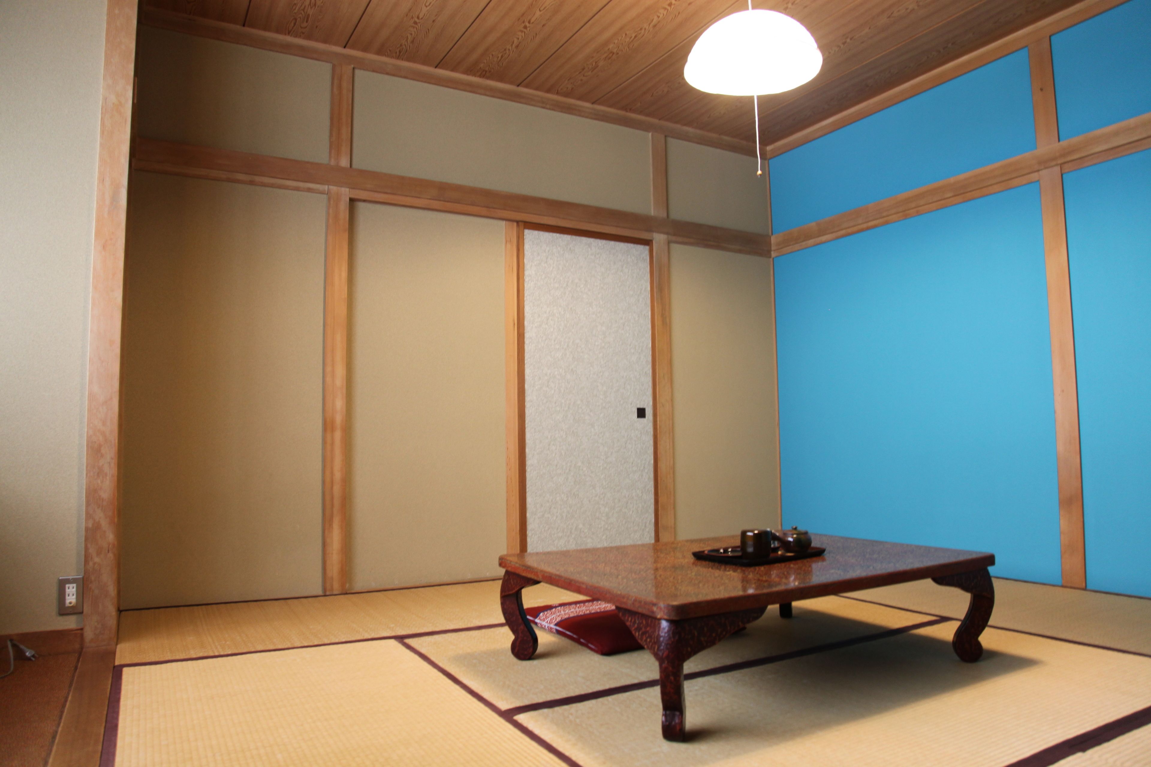 A traditional Japanese room with tatami flooring, a low wooden table, and shoji screens.