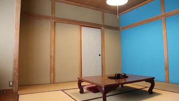 A traditional Japanese room with tatami flooring, a low wooden table, and shoji screens.