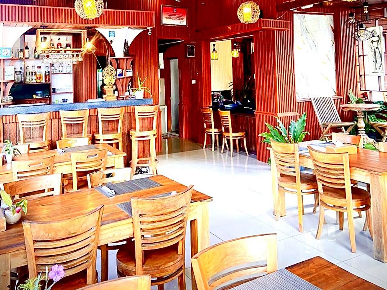 A restaurant with wooden furniture, a bar area, and a red interior.