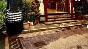 Un café con letrero, mesas al aire libre y un cartel anunciando un jardín.