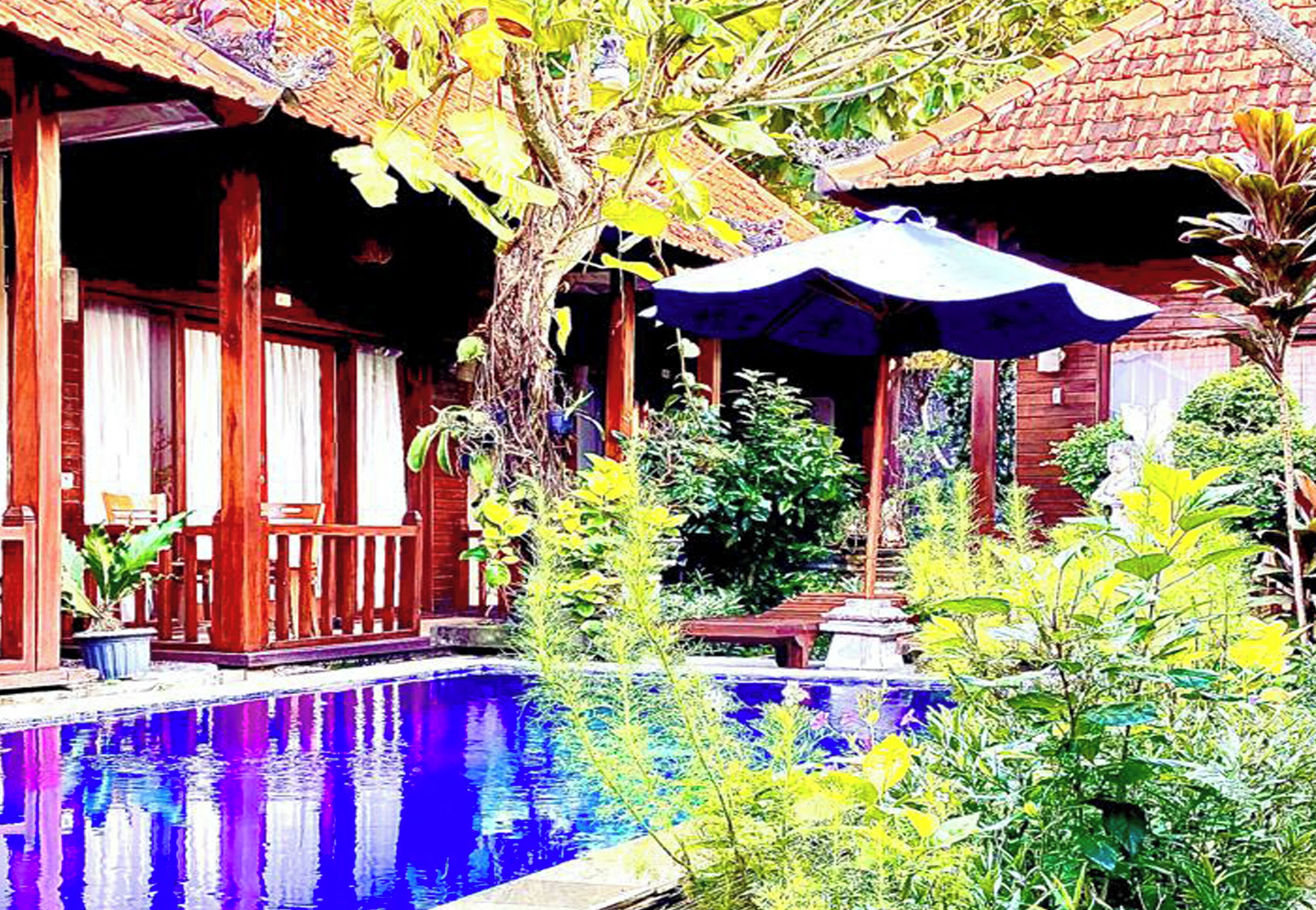 Una casa de madera tradicional con piscina, rodeada de exuberante follaje y un techo de tejas.
