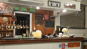 A bar area with a reception desk, free WiFi sign, and various liquor bottles.