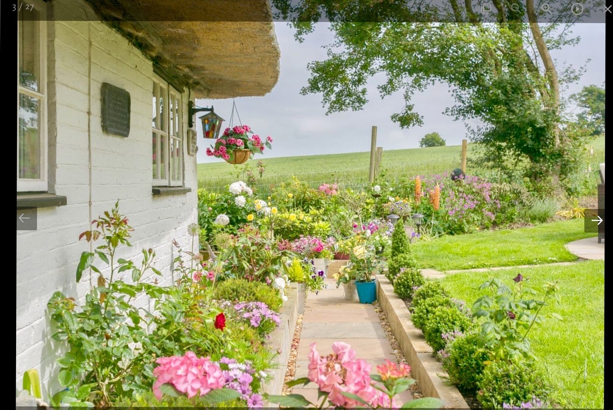 Une maison blanche avec un chemin de jardin menant à une porte blanche.