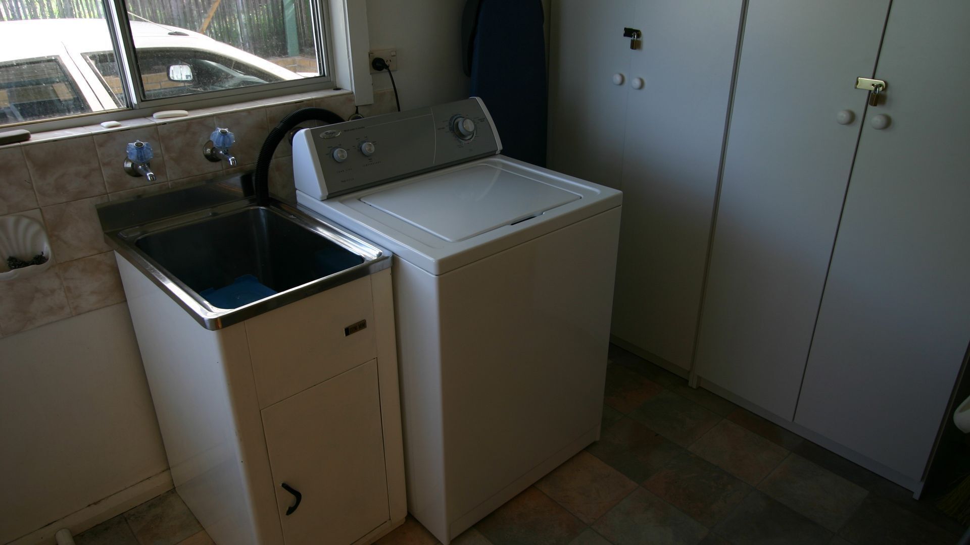 A compact laundry area with a washing machine and a sink.