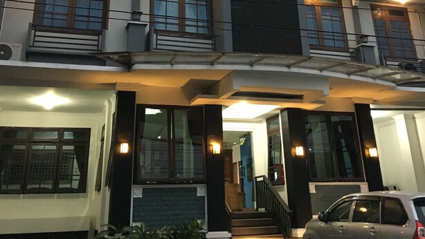 A multi-story building with a sign reading "KRISTINA HOTEL." It features balconies with railings, air conditioning units, and a staircase leading to the entrance. - Hotel Kristina (Yogyakarta)