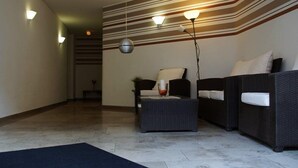 A modern living area with a sofa, a small table, and a lamp. - Gasthof Hotel Kopf (Riegel am Kaiserstuhl)