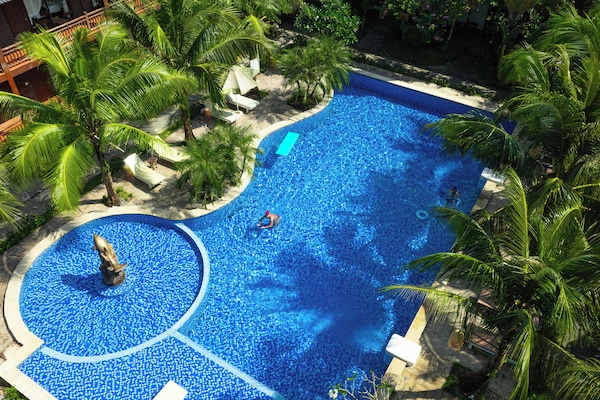 Una piscina al aire libre, sillones reclinables de piscina