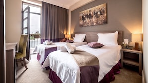 A hotel room with two beds, a desk, and a chair. - Frontier Europe Hotels Group (Siret)