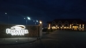 The Frontier Hotel sign with a stone facade and illuminated lettering. - Frontier Europe Hotels Group (Siret)